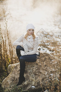 一位坐在918号公路旁的大石头上女孩冬季肖像图片