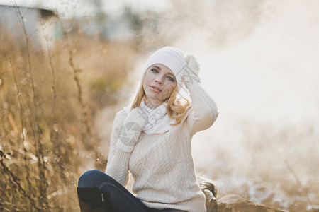 一位女孩坐在9186号公路旁边的一块大石头上冬季肖像图片