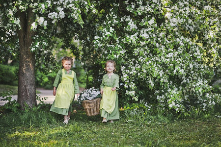 两个女孩拿着一篮花女朋友提了一个柳条篮子里面装满了花用来装饰花园图片