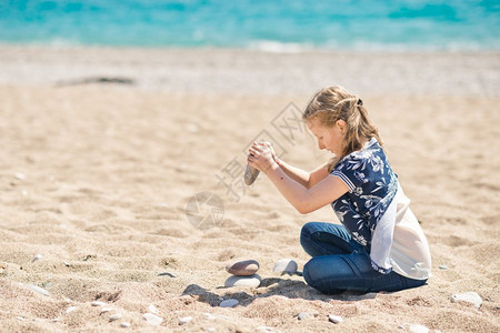 女孩在海边玩着圆石小孩大头8361图片