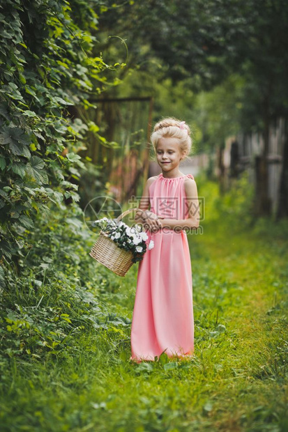 穿着粉红色裙子的孩在花园里走过658图片