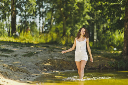 身穿白短裙的女孩沿着水池边缘632行走图片