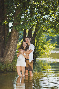 快乐的情侣在湖岸边拥抱图片