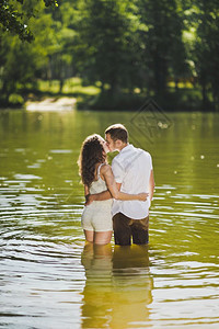 在森林湖岸边的温柔拥抱绿湖6314海岸一对年轻夫妇的肖像图片