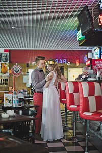 在咖啡馆抱的年轻男女穿着服装的一对漂亮夫妇在587咖啡馆的背景上图片