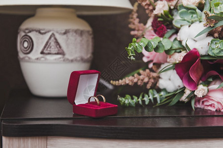 一束花和结婚戒指放在桌子上图片