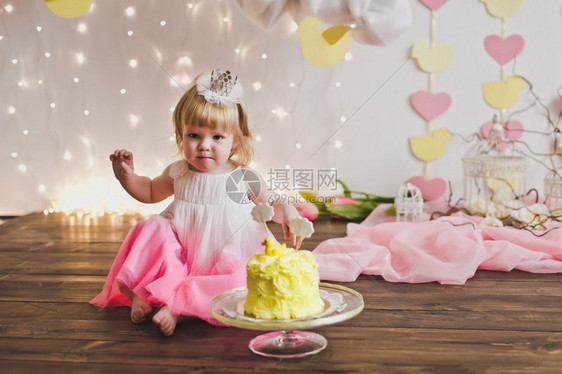 小女孩坐在一个甜蛋糕前孩子庆祝了第一个生日5374图片