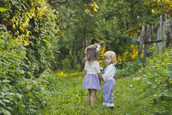 孩子们沿着夏令营走一个男孩和女走在绿色花园4761图片