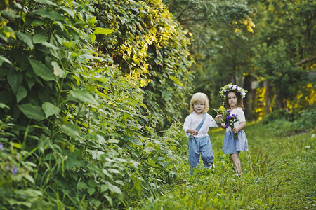 孩子们沿着夏令营走一个男孩和女走在绿色花园4762图片