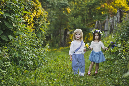 孩子们沿着夏令营走一个男孩和女走在绿色花园476图片
