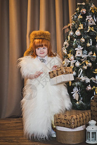 圣诞树旁边的婴儿穿着456毛皮的公主圣诞肖像背景图片