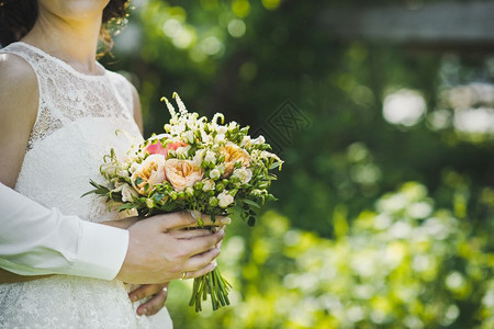 女人拿着一束玫瑰花包在新娘43手里图片