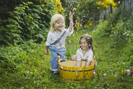 儿童在花园里玩水儿童在4756盆地里泼水图片