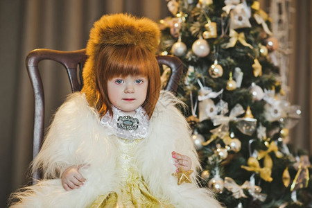 圣诞树周围穿着皮草大衣的小孩肖像图片