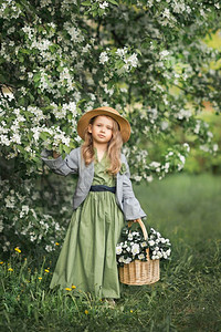 一个小女孩穿过开阔的花园一个穿着简单衣服的小女孩带着一篮子白色紫罗兰1784图片