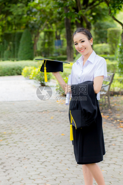 毕业帽子手握着快乐的毕业女学生图片