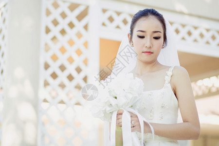 在婚礼当天美丽的年轻女子穿着白色礼服在花园里公的女肖像图片