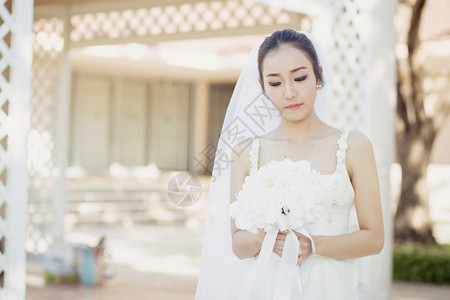 在婚礼当天美丽的年轻女子穿着白色礼服在花园里公的女肖像图片