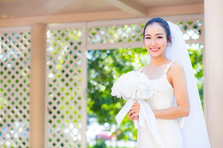 在婚礼当天美丽的年轻女子穿着白色礼服在花园里公的女肖像图片