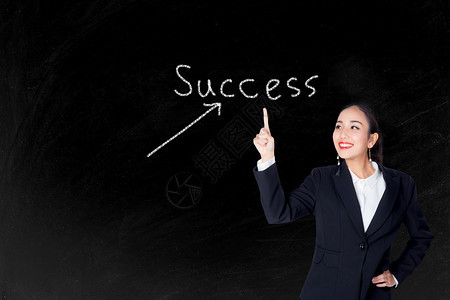 快乐的年轻商业女指出成功文本黑板背景图片