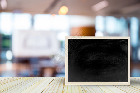 餐桌上的白黑板在模糊的餐厅上有bokeh背景文字空间模拟产品显示蒙太奇背景图片