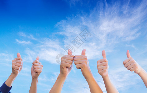 一群人类拳头举起拇指天空背景团队合作业务概念图片