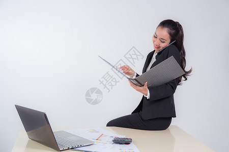 商业女人通过档案查找文件在白背景的办公桌上摆着座位图片
