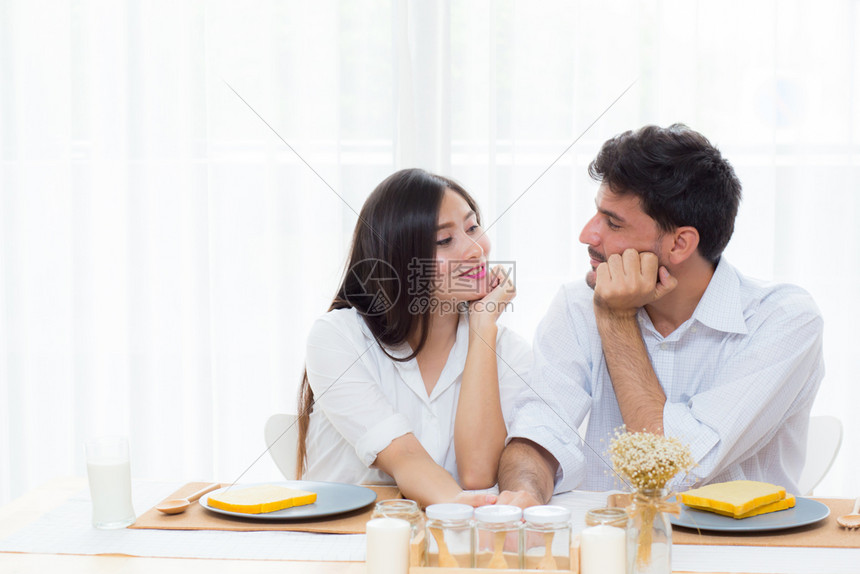 欢欣的亚洲青年男女在厨房吃午饭和聊天时一起吃饭图片