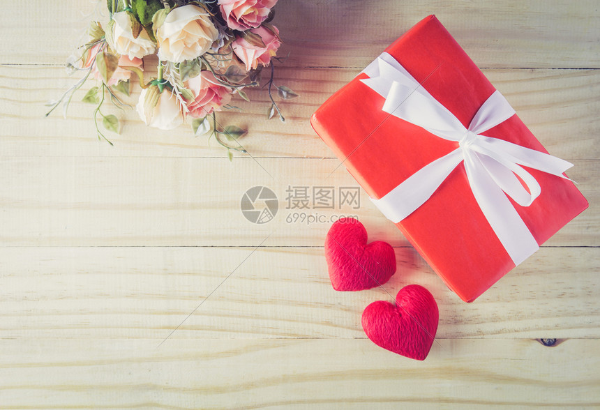 礼物盒白弓丝带和心鲜花放在木桌背景的顶端视图情人节的精华在概念上图片