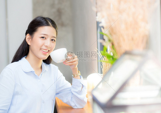 美丽的年轻女在咖啡馆喝早上微笑女孩坐在咖啡店吃早餐图片