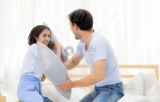 在卧室玩枕头搏斗爱的概念关系亚裔年轻情侣快乐图片