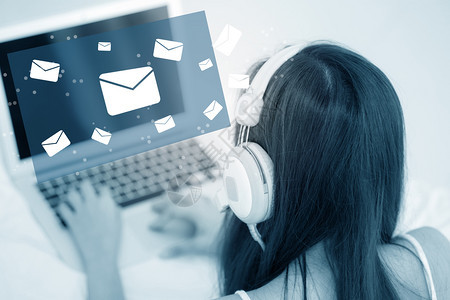 使用笔记本电脑键盘头部话发送子邮件在网络互联上以蓝调系女孩使用笔记本通信概念图片
