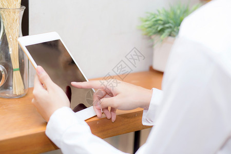 女手触屏使用数字平板电脑和网上咖啡店通信概念背景图片