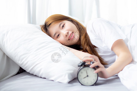清晨关闭闹钟醒来后用放松和生活方式概念睡觉图片