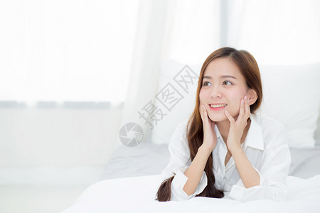 美丽的肖像年轻亚洲女人说谎和微笑早晨醒来时日出生活方式和放松概念图片