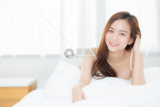 美丽的肖像年轻亚洲女人说谎和微笑早晨醒来时日出生活方式和放松概念图片