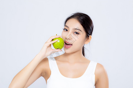 肖像的亚洲妇女微笑地抱着和吃绿色苹果水和美丽的身体饮食与白种背景隔绝女孩体重瘦有纤维素或卡路里健康和概念图片