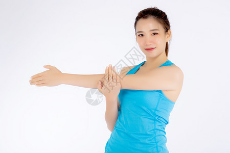 年轻像样的女站在白色背景上孤立的伸展肌肉手臂上女孩穿运动服和瑜伽是为了健康概念图片