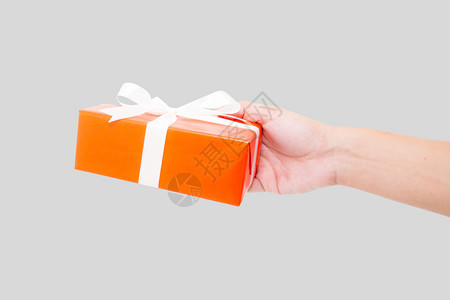 红礼盒白丝带将手放在色背景上用于圣诞节和新年或假日图片