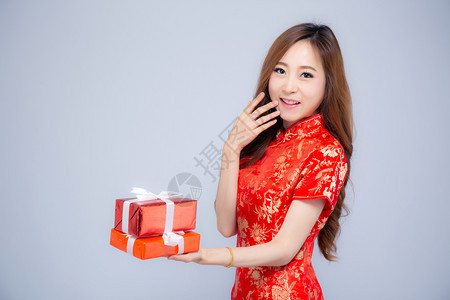 新年快乐美丽的肖像年轻亚洲女拿着红色礼物盒孤立在白色背景上女孩微笑展示现货购买假日概念图片