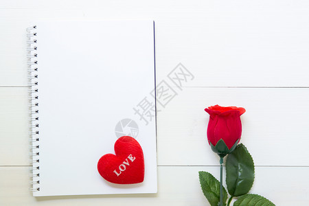 红玫瑰花笔记本和心形木制桌上有复空间2月14日爱浪漫情人节的概念图片