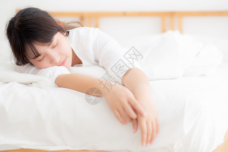 睡在舒适快乐的床上在卧室健康和概念中放松和闲暇的女孩图片