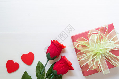在木桌上赠送红色玫瑰花礼品和蝴蝶结彩带心形礼盒2月14日浪漫情人节情人节概念顶视图图片
