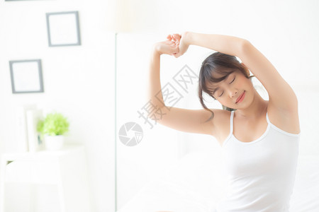 美丽的肖像年轻亚洲女在睡房醒来后躺在床上休息新的一天休息健康和背面观生活方式的概念图片