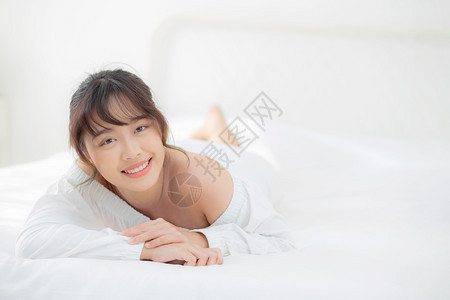 美丽的肖像年轻亚洲女人躺着笑早上醒来清晨日出美丽可爱的女孩快乐地躺在床上睡卧室里图片