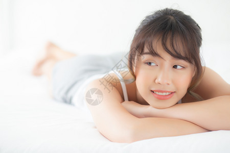 美丽的肖像年轻亚洲女人躺着笑早上醒来清晨日出美丽可爱的女孩快乐地躺在床上睡卧室里图片