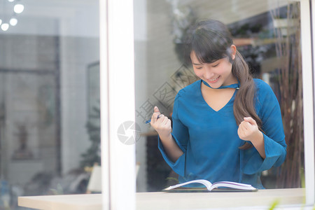 年轻的亚洲女作家写在笔记本或日记上的美丽肖像快乐和兴奋生活方式亚洲女孩规划工作和成功教育和商业理念图片