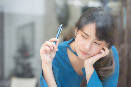 美丽的肖像年轻的亚洲女作家微笑着思考的想法和写在笔记本或日记上的快乐亚洲女孩的生活方式是学生女规划工作教育和商业观念图片