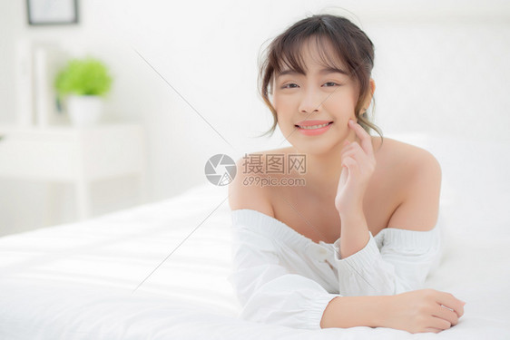 美丽的肖像年轻亚洲女人躺着笑早上醒来清晨日出美丽可爱的女孩快乐地躺在床上睡卧室里图片