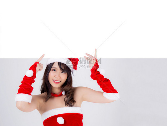 美丽的年轻圣诞老人女子在节假期和新年的广告中展示空的标语纸海报图片
